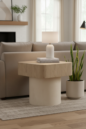 Modern living room with a hexagonal side table, lamp, and plant.
