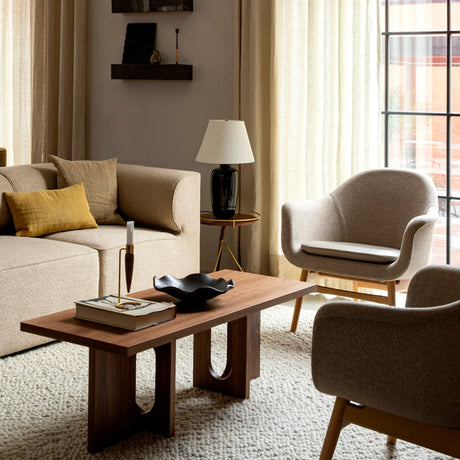 Modern living room with beige sofa, armchair, and wooden coffee table.