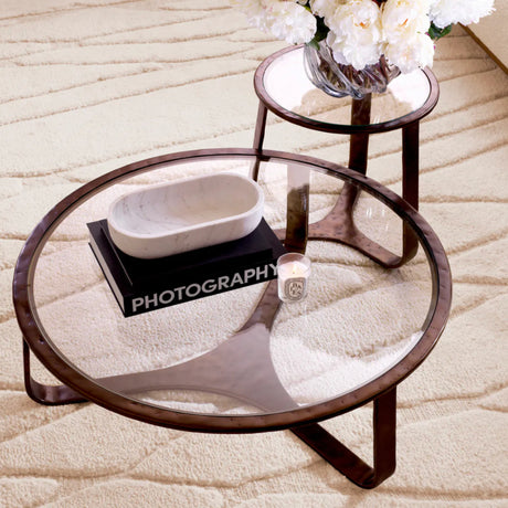 Round glass coffee table with wooden frame on a textured surface
